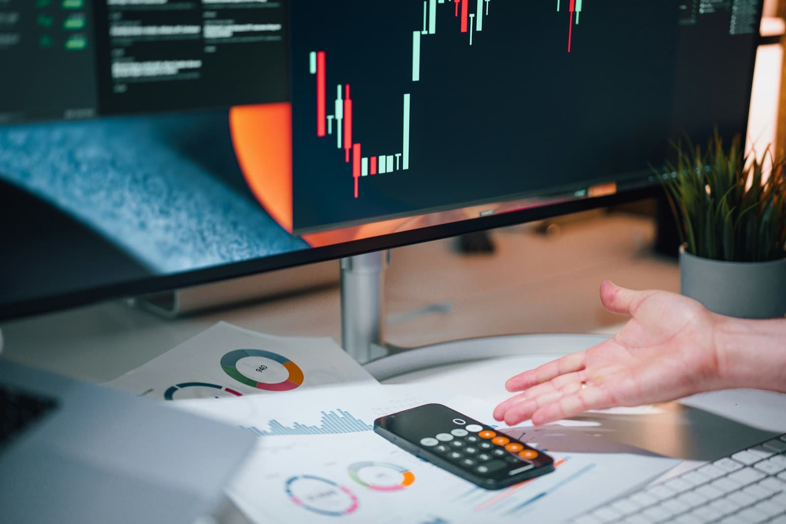 A calculator and financial charts on a desk