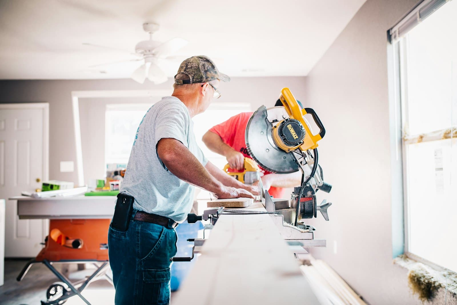Contractors cutting trim with a mitre saw during a renovation