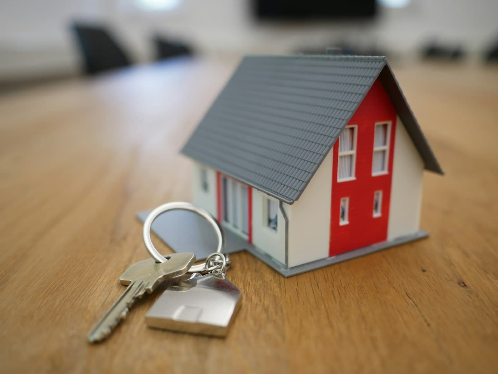 A small model house held in someone's hands