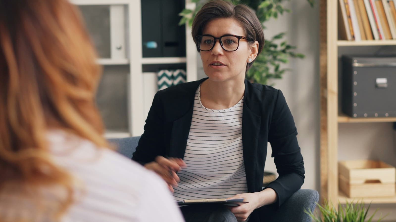 A therapist listening to a client in a bright office